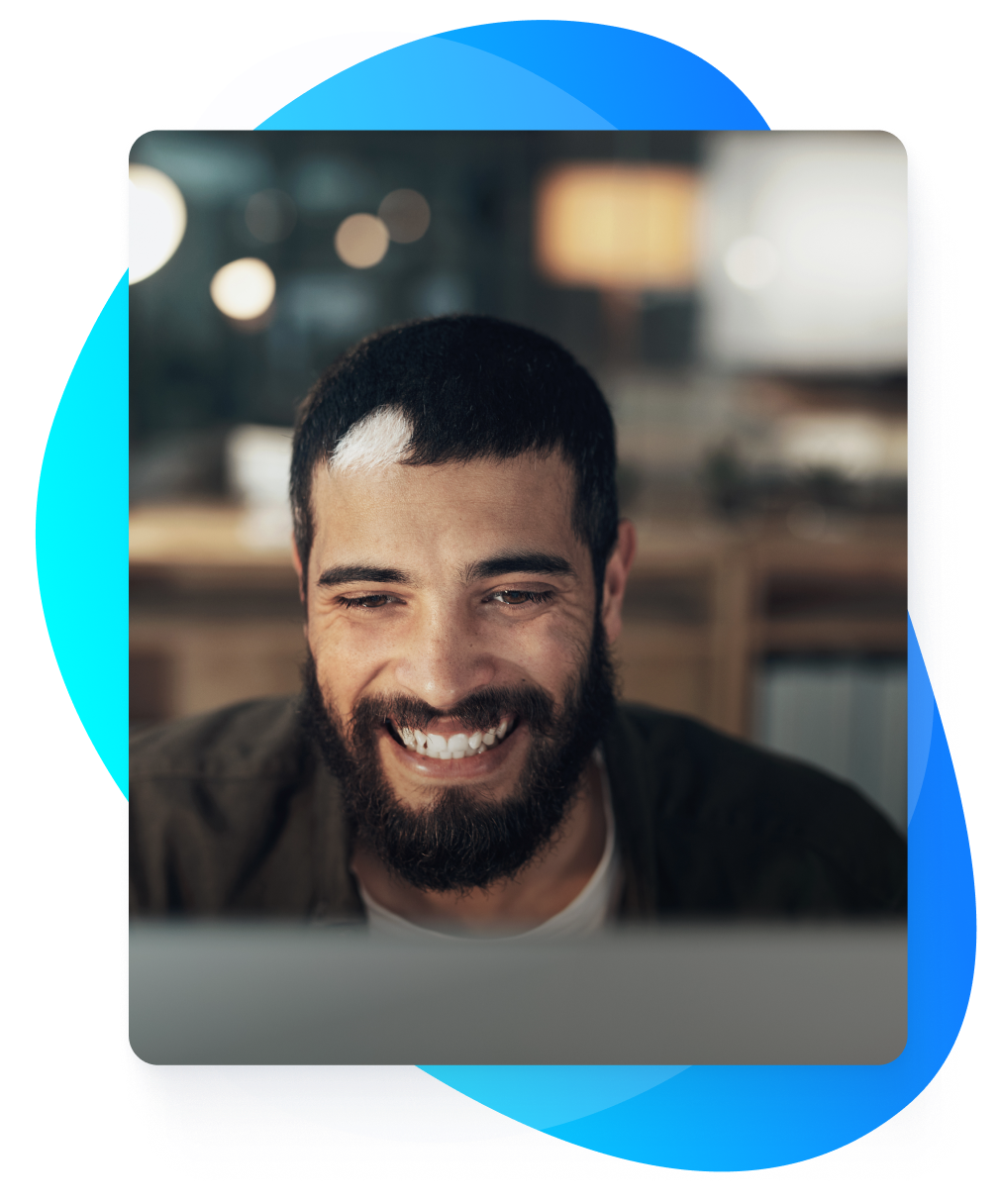 Man smiling looking at computer screen